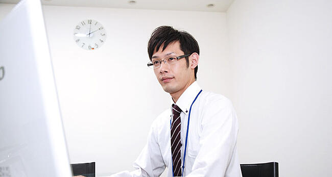 スーツを着た男性社員がパソコンを操作する様子