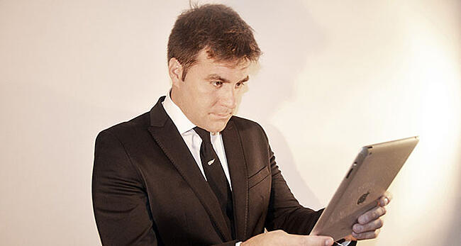 iPadを操作するスーツを着た男性の様子