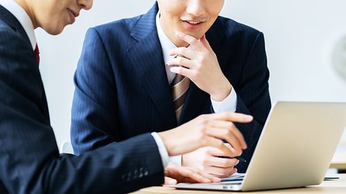PCで資料の説明する会社員のイメージ写真