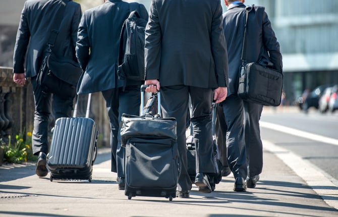A group of businessmen pulling suitcases with luggage.jpeg
